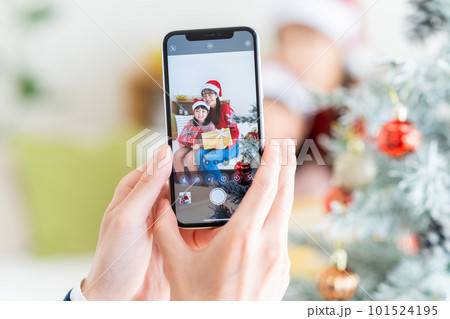 クリスマスの写真を撮る若い家族 101524195