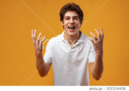 Portrait of a satisfied young man celebrating success over yellow background Portrait of a satisfied young man celebrating success over yellow background 101524436
