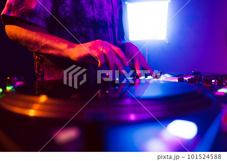 Close up of DJ hands on dj console mixer during concert in the club 101524588