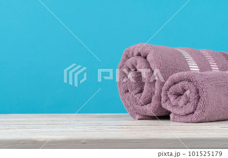 Stack of rolled towels on a wooden table Stack of rolled towels on a wooden table 101525179