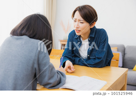リビングで宿題をする小学生とお母さん 101525946