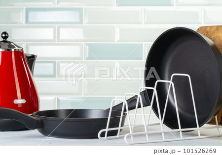 Clean and dry cooking pans on a kitchen counter 101526269