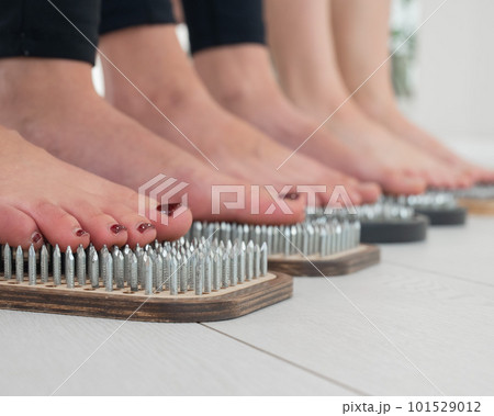 Close-up of three women's feet on sadhu's nails. Close-up of three women's feet on sadhu's nails. 101529012