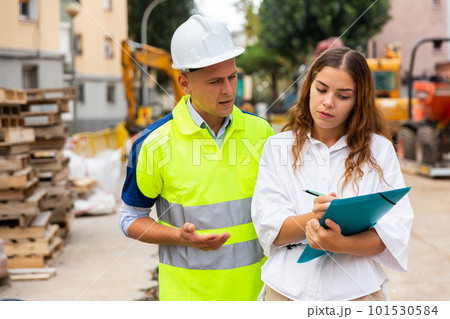 Architect woman and foreman discussing in construction site 101530584