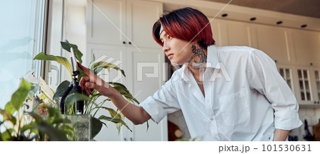 Asian guy using smartphone on a tripod to create a video at home 101530631