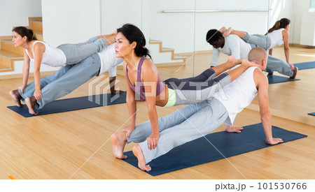 Couples practicing yoga with partner at studio 101530766