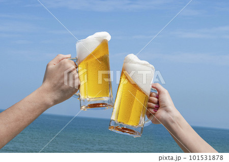 青空と海の前でビールで乾杯 101531878
