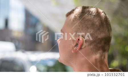 Close-up of a hearing aid on a man's ear.  101532701