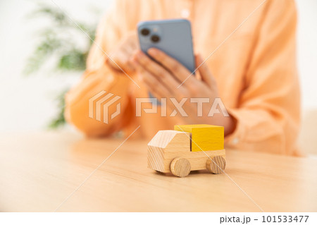 スマホを操作する女性の手とトラック 101533477