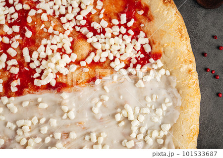 Closeup on raw pizza base with sauces 101533687