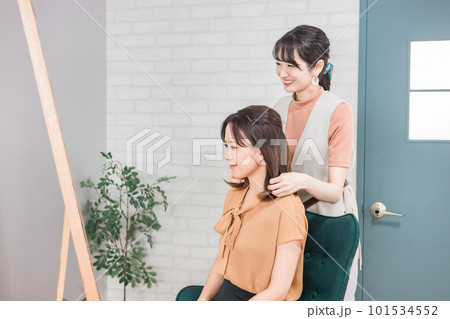 美容室・ヘアサロンで髪型を相談するアジア人女性の客とカウンセリングする美容師・スタイリスト 美容室・ヘアサロンで髪型を相談するアジア人女性の客とカウンセリングする美容師・スタイリスト 101534552