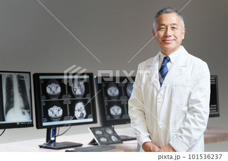 モニターの前に立ち、視線を向ける白衣のシニア男性 モニターの前に立ち、視線を向ける白衣のシニア男性 101536237