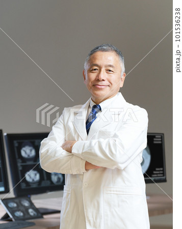 モニターの前で腕組みをする白衣のシニア男性 モニターの前で腕組みをする白衣のシニア男性 101536238