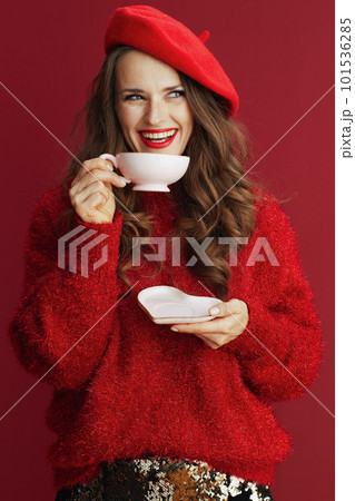 smiling stylish female in red sweater and beret with tea cup smiling stylish female in red sweater and beret with tea cup 101536285