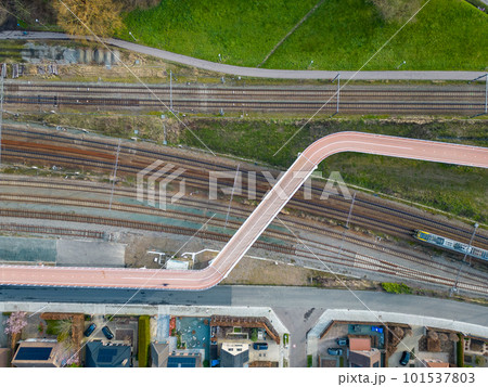 Aerial view shot by a drone of a cyclists and pedestrian bridge over the railroad tracks 101537803