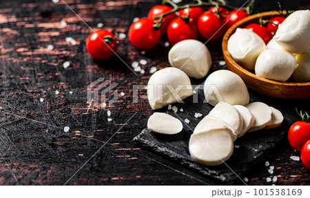 Sliced mozzarella on a stone board with tomatoes. Sliced mozzarella on a stone board with tomatoes. 101538169