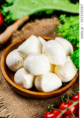 Mozzareella in a plate on a napkin with tomatoes and lettuce. 101538367