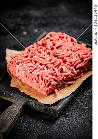 A piece of raw minced meat on a cutting board. A piece of raw minced meat on a cutting board. 101538445