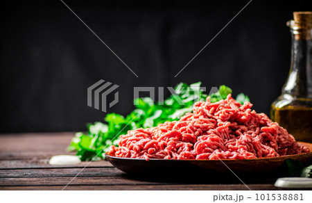 Minced meat on a plate on the table with parsley. Minced meat on a plate on the table with parsley. 101538881