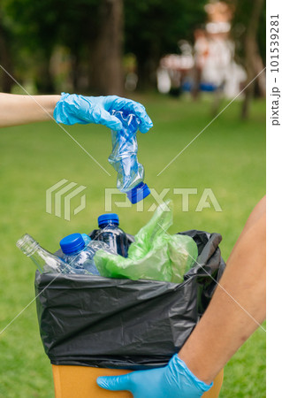 people hand holding garbage bottle plastic and glass putting into recycle bag. plastic concept.. 101539281