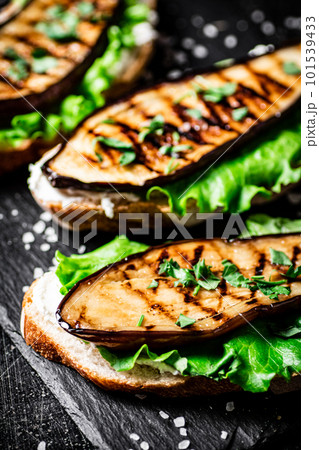 Grilled eggplant sandwich on a stone board. 101539433