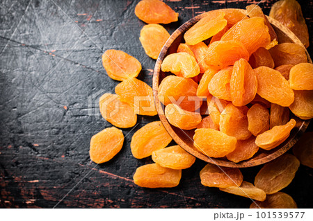 Full wooden plate with dried apricots. Full wooden plate with dried apricots. 101539577