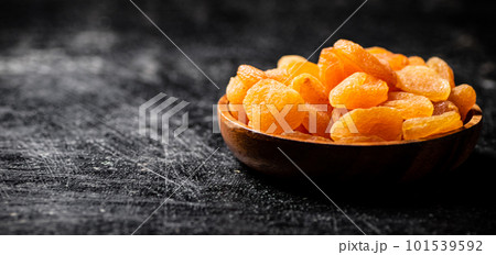 Delicious dried apricots in a wooden plate. 101539592