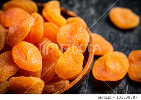 Delicious dried apricots in a wooden plate. 101539597