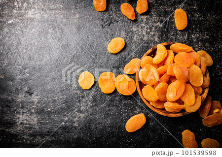Delicious dried apricots in a wooden plate. 101539598