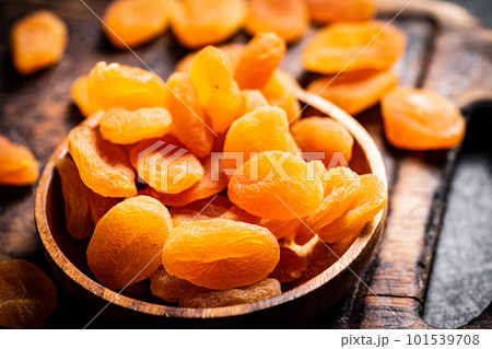 A bunch of dried apricots on a plate and on the table. A bunch of dried apricots on a plate and on the table. 101539708