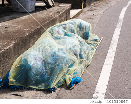 カラス除けネットをかけたゴミ集積場の家庭ごみ 101539847