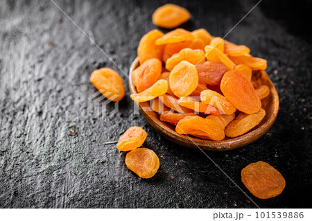 Dried apricots in a wooden plate on the table. 101539886