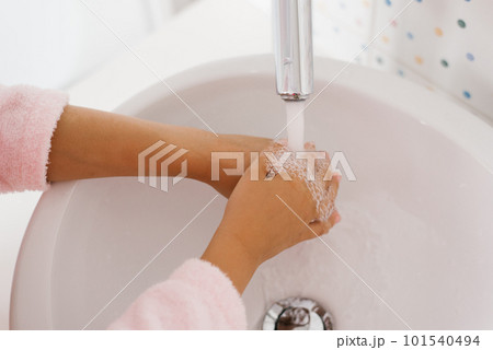 Close up view of young child washing hands with soap in sink 101540494