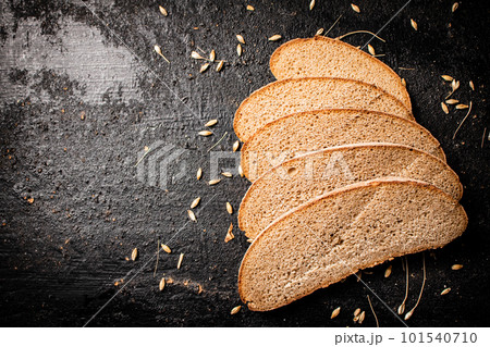 Slices of rye bread with grain on the table. 101540710