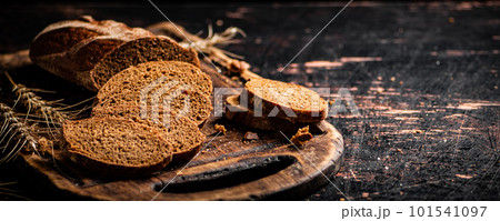 Slices of fragrant bread on a wooden cutting board. 101541097