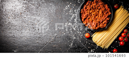 Bolognese sauce on a stone board with tomatoes, spices and dry pasta. Bolognese sauce on a stone board with tomatoes, spices and dry pasta. 101541693