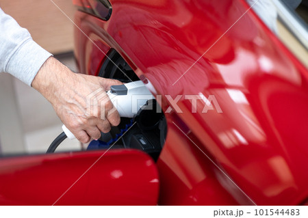 PHEVの赤い自動車に充電しているところ 101544483