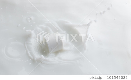 Cosmetic container white lotion droplet fly splashing. Milk lotion pour float to cosmetic bottle. Moisturizer lotion explosion spill. White background isolated high speed shutter freeze top view 101545023