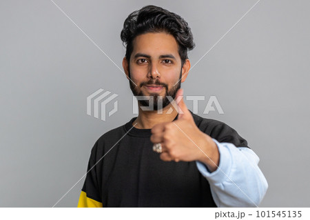 Indian young man raises thumbs up agrees or gives positive reply recommends advertisement likes good Indian young man raises thumbs up agrees or gives positive reply recommends advertisement likes good 101545135