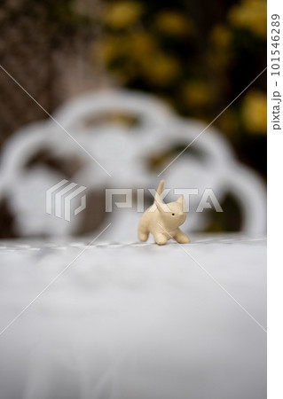 庭のテーブルの上に置いてある白い猫の陶器の置物 101546289