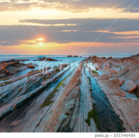 Twilight ocean coast with ribbed stratiform rock. Twilight ocean coast with ribbed stratiform rock. 101546486