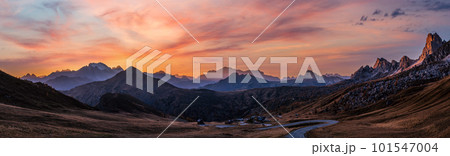 Sun glow in evening hazy sky. Mountain panoramic peaceful view from Giau Pass. 101547004