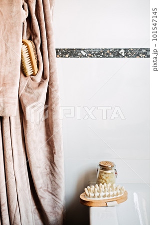 Wooden tray with home spa supplies and bathrobe in modern home bathroom for relaxing rituals. Spa decoration, natural organic products on a bathtube Wooden tray with home spa supplies and bathrobe in modern home bathroom for relaxing rituals. Spa decoration, natural organic products on a bathtube 101547145