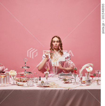Shot of beautiful woman, princess wearing renaissance pink dress and standing with wine glass over studio background. Manners eating 101548093