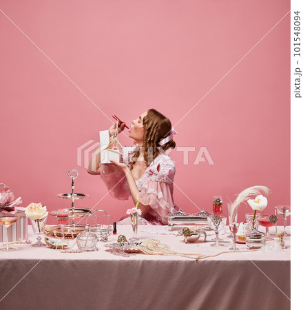 Shot of hungry adorable queen wearing baroque dress and eating with chinese chopsticks near festive laid table. Asian cuisine 101548094