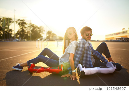 Young man and woman riding on the Hoverboard in the park. content technologies. a new movement. Young man and woman riding on the Hoverboard in the park. content technologies. a new movement. 101548697