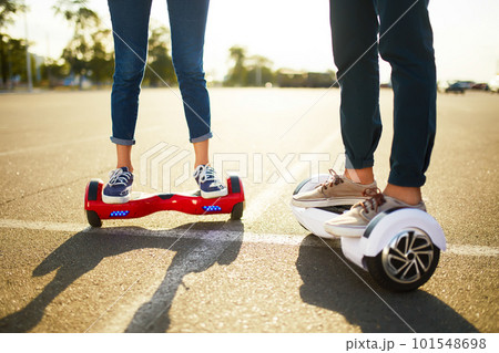 Young man and woman riding on the Hoverboard in the park. content technologies. a new movement. Young man and woman riding on the Hoverboard in the park. content technologies. a new movement. 101548698