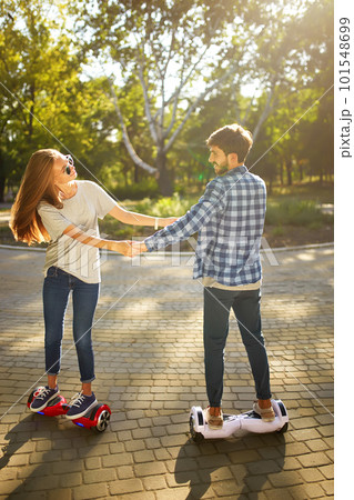 Young man and woman riding on the Hoverboard in the park. content technologies. a new movement. Young man and woman riding on the Hoverboard in the park. content technologies. a new movement. 101548699