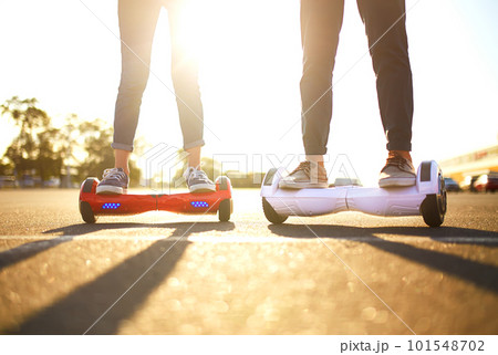 Young man and woman riding on the Hoverboard in the park. content technologies. a new movement. Young man and woman riding on the Hoverboard in the park. content technologies. a new movement. 101548702