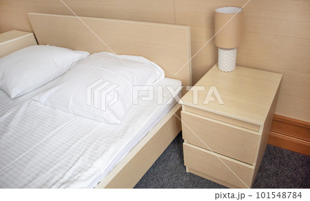 Bed and bedside table with lamp, modern bedroom interior 101548784